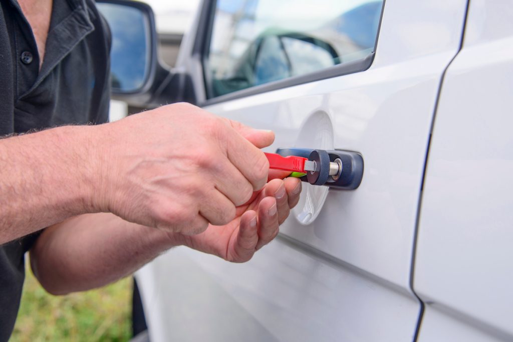 Locksmith opening a car door with special tools